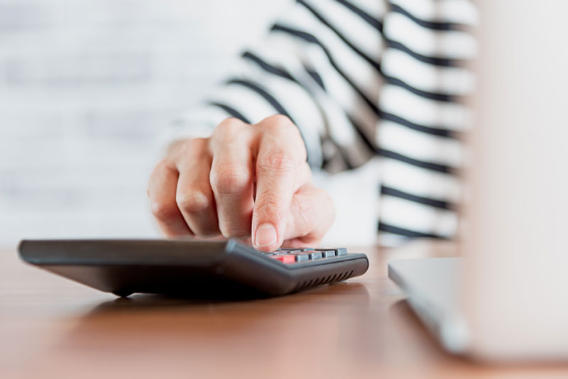 Guy typing into calculator how much he will save with commonwealth prosthodontics