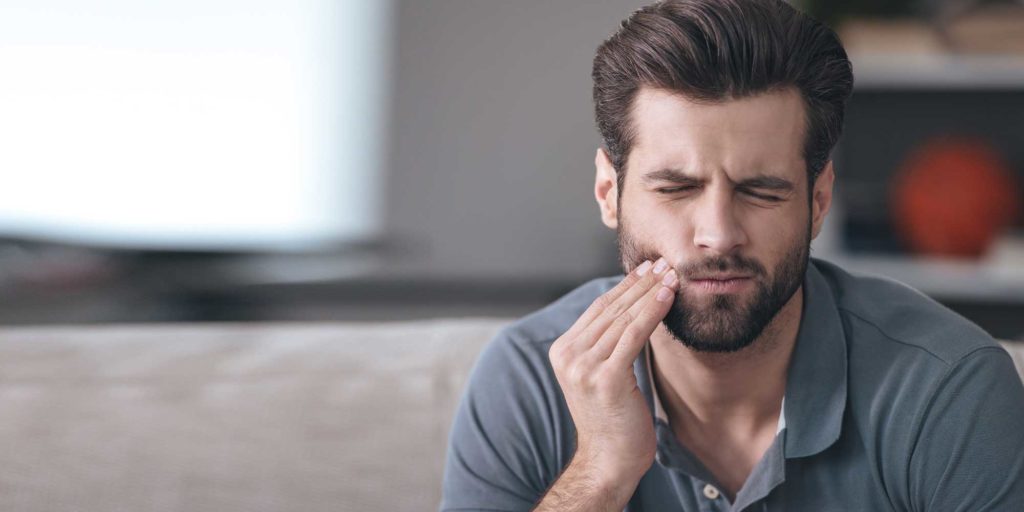 Guy in pain grabbing mouth